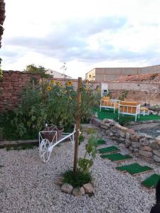 un jardin avec une brouette et un arbre dans une cour dans l'établissement La Quibla de Abuhan, à Caudé