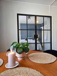 a candle on a wooden table with a view of the ocean at Little Paris, 1 bedroom apartment in Pietarsaari