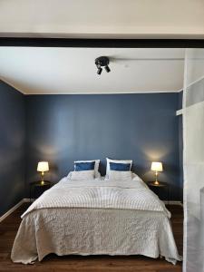1 dormitorio con 1 cama grande y paredes azules en Little Paris, 1 bedroom apartment, en Jakobstad