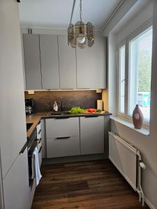 una cocina con armarios blancos y fregadero en Little Paris, 1 bedroom apartment, en Jakobstad
