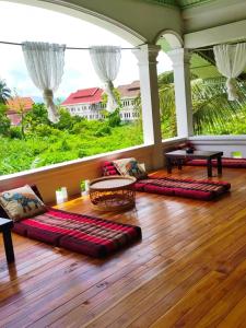 a living room with pillows on a wooden floor at 天堂鸟花园客栈 in Luang Prabang