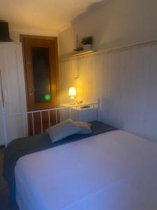 Un dormitorio con una cama blanca con luz. en camera con giardino e piscina, en Scafati