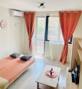 a bedroom with two beds and a table and a window at City Residence Apartments Sofia in Sofia