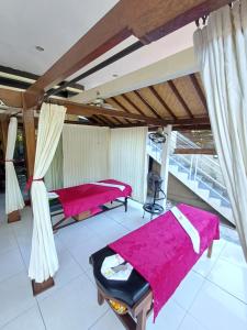 twee bedden in een kamer met roze lakens bij Balinda Rooms & Villa in Lovina