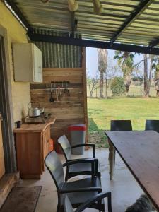 a kitchen with a table and chairs and a table and a stove at KatiKati Eco Lodge in White River