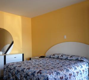 a bedroom with a bed and a yellow wall at Motel Saint-Jacques in Montréal