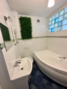 a white bathroom with a tub and a sink at Apartament Centrum in Zielona Góra