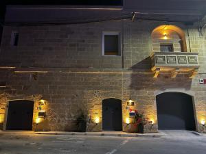 un edificio in mattoni con tre porte e una finestra di Tac-Cnic Heritage Living - Apartment, Spa Suite & Spectacular Views a Żebbuġ