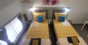 Gračac的住宿－ANA，配有两张黄色和蓝色枕头的床铺
