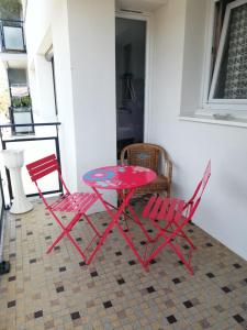 duas cadeiras vermelhas e uma mesa e cadeiras vermelhas em Le Jeandrée em Annecy