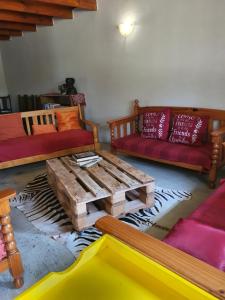 sala de estar con sofás y mesa de centro de madera. en KatiKati Eco Lodge en White River