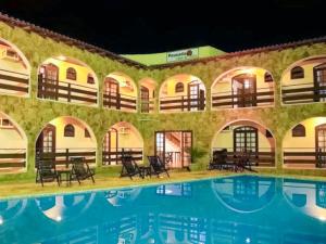 un complejo con piscina por la noche en VELINN Pousada Casa de Pedra Ilhabela, en Ilhabela