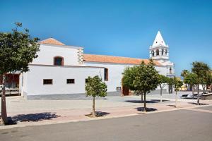 eine Kirche mit einem weißen Gebäude mit einem Kirchturm in der Unterkunft Apartamento Lancelot in Puerto del Rosario