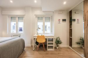 1 dormitorio con escritorio y silla amarilla en AmazINN Places Blasco de Garay 105, en Madrid