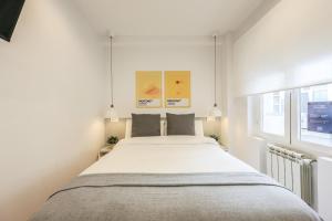 a white bedroom with a large bed in it at AmazINN Places Blasco de Garay 105 in Madrid
