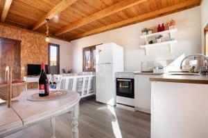 a kitchen with white appliances and a table with a bottle of wine at Casa Barranco de la Sal in Puerto del Rosario +17 photos