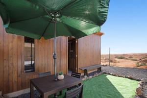 a patio with a table and a green umbrella at Casa Barranco de la Sal in Puerto del Rosario