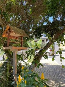 drewniany domek dla ptaków siedzący na drzewie w obiekcie Hospedagem Estação w mieście Domingos Martins