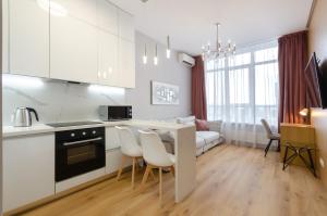 uma cozinha e sala de estar com mesa e cadeiras em 19267 Residential complex Central Park cozy apartment em Kiev