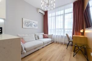 a living room with a white couch and a window at 19267 Residential complex Central Park cozy apartment in Kyiv