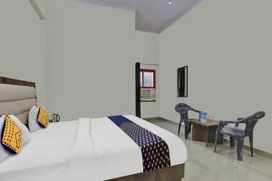 1 dormitorio con 1 cama, mesa y sillas en SPOT ON Abhinandan Hotel And Restaurant, en Pratāpgarh
