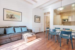 een woonkamer met een bank en een tafel en stoelen bij Charming Apartment In Clot in Barcelona
