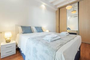 een slaapkamer met een groot bed en handdoeken bij Charming Apartment In Clot in Barcelona