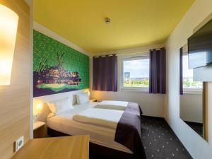 a hotel room with a bed and a window at B&B Hotel Oberhausen am Centro in Oberhausen