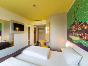 ein Hotelzimmer mit einem Bett und einem TV in der Unterkunft B&B Hotel Oberhausen am Centro in Oberhausen