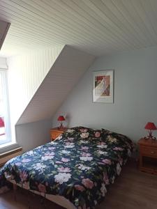 1 dormitorio con 1 cama con manta de flores en Maison proche centre équestre et forêt avec jardin, en Le Touquet-Paris-Plage