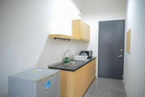 uma pequena cozinha com um lavatório e um frigorífico em Garden at Empire Damansara em Petaling Jaya