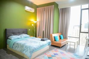 um quarto com paredes verdes e uma cama e uma cadeira em Garden at Empire Damansara em Petaling Jaya