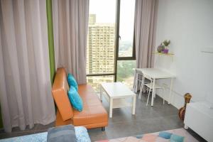 uma sala de estar com um sofá, uma mesa e uma janela em Garden at Empire Damansara em Petaling Jaya