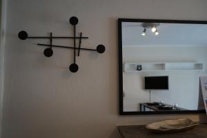 un espejo en una pared junto a una mesa con un espejo en Casa GiaGia, en Bérgamo
