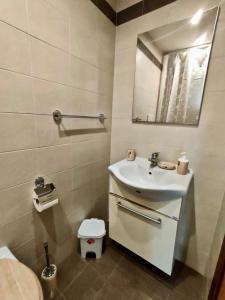een badkamer met een witte wastafel en een spiegel bij Casa Vacanza L'Alchimista Mottola in Mottola