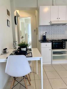 a kitchen with a white table and a white chair at Casa D'oro A1 in Larisa
