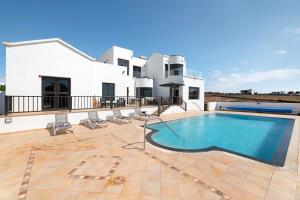 a villa with a swimming pool in front of a house at Casa Insitu in El Mojón