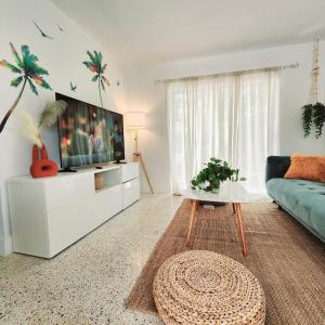 ein Wohnzimmer mit einem TV und einem blauen Sofa in der Unterkunft Cozy Apartment Near Brickell in Miami