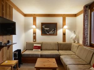 a living room with a couch and a tv at Appartement rénové proche station avec balcons et vue, 3 ch, 10 pers - FR-1-181-2457 in La Plagne Tarentaise