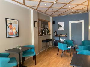 un restaurante con mesas y sillas azules y un bar en Good Morning Karlstad City, en Karlstad