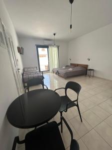 a living room with a table and chairs and a bed at Zefyros Studios in Plaka