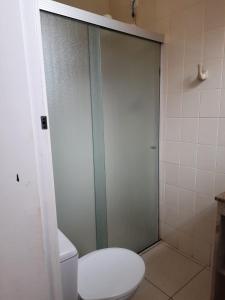 La salle de bains est pourvue de toilettes et d'une porte de douche en verre. dans l'établissement Solar do Jenipapo, à Tamoios