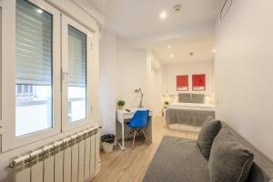 1 dormitorio con cama, escritorio y ventana en AmazINN Places Blasco de Garay 113, en Madrid