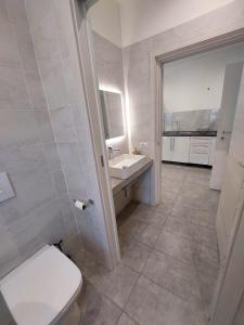 La salle de bains blanche est pourvue de toilettes et d'un lavabo. dans l'établissement Oasi Santaquilina, à Rimini