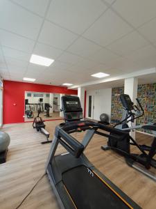 un gimnasio con varias cintas de correr y bicicletas estáticas en Nemea Appart Hotel Coliseum Amiens Centre en Amiens