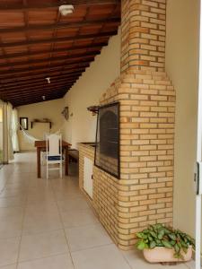 - une cheminée en briques dans le salon avec une table dans l'établissement Solar do Jenipapo, à Tamoios