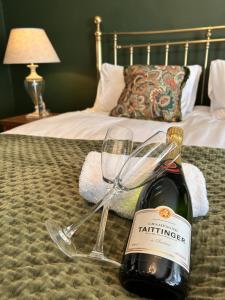 a bottle of wine and a glass on a bed at The Lodge at Salhouse in Norwich