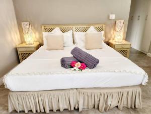 Una gran cama blanca con almohadas y flores. en Villa A23 - Selborne Golf Estate, en Pennington