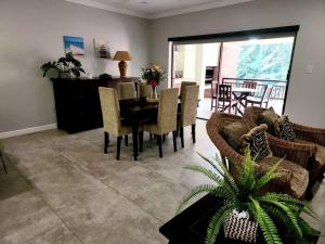 Una sala de estar con una mesa y sillas y un sofá. en Villa A23 - Selborne Golf Estate, en Pennington