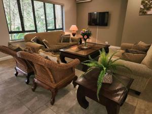 Una sala de estar con un sofá y sillas y una mesa. en Villa A23 - Selborne Golf Estate, en Pennington